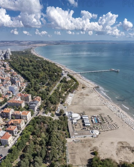 City beach with a long pier extending into the ocean. Aerial view to bech and sea garden of Burgas, Bulgaria. Black sea