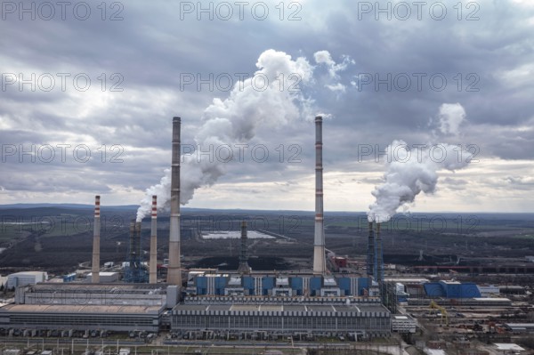 Aerial view of a large power plant with smokestacks emitting smoke into a cloudy sky. Aerial view of thermal power plant Maritsa East 2 Stara Zagora Region, Bulgaria
