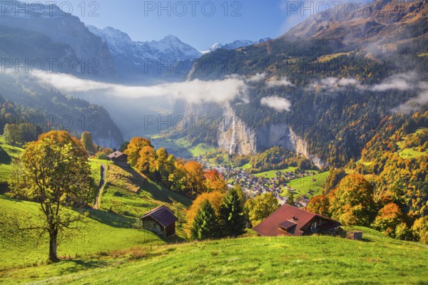 View from the village of the Lauterbrunnen Valley with Staubbach waterfall in autumn with morning fog, Wengen, Bernese Oberland, Canton of Bern, Switzerland