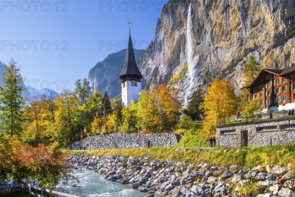 Village church with Staubbach waterfall in autumn, Lauterbrunnen, Bernese Oberland, Canton of Bern, Switzerland