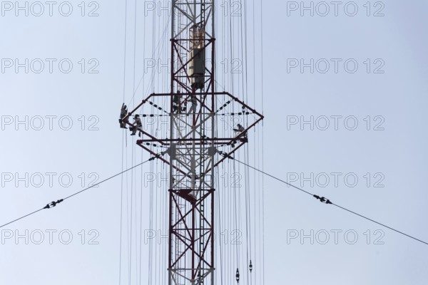 Men painting the highest Czech construction radio transmitter tower Liblice Czech republic