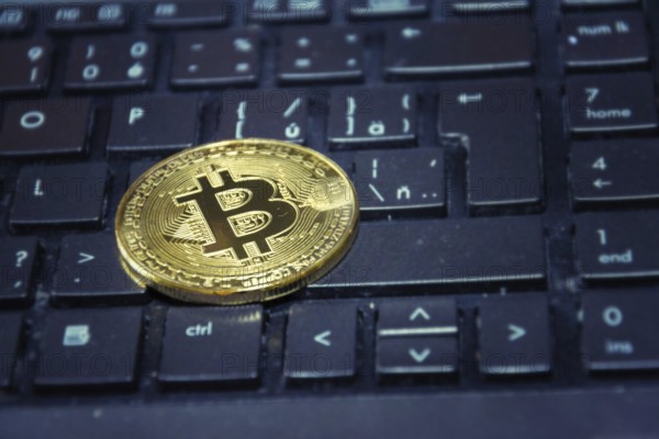Golden bitcoin coin lying on green computer keyboard, cryptocurrency investing concept Prague Czech republic