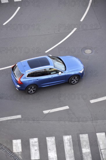 Blue unrecognizable car moving on road with broken line near pedestrian crossing, driverless autonomous technology concept, aerial birds eye view Prague Czech republic