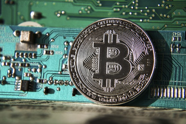 Silver bitcoin coin in front of computer motherboard, cryptocurrency mining and investing concept Prague Czech republic