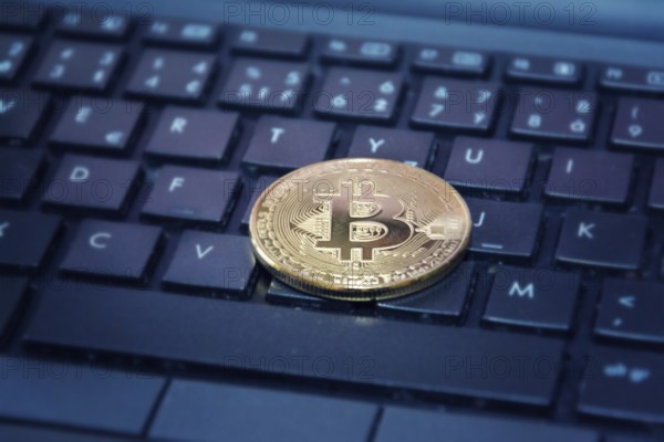 Golden bitcoin coin on computer keyboard, cryptocurrency bitcoin mining concept Prague Czech republic