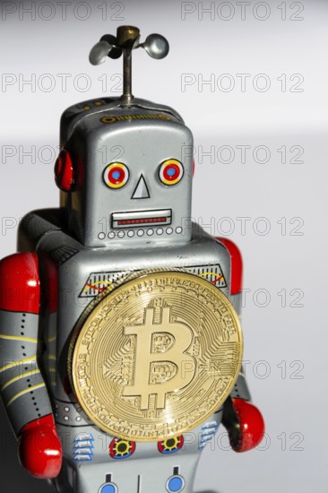 Vintage tin toy robot with bitcoin coin, cryptocurrency mining concept Prague Czech republic
