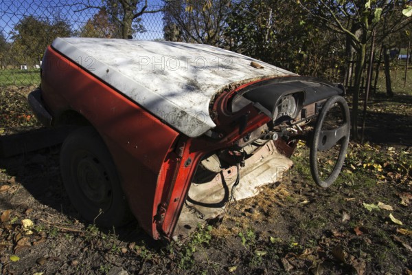 Rusty vintage car cut in half on a sunny day in autumn garden Prague Czech republic