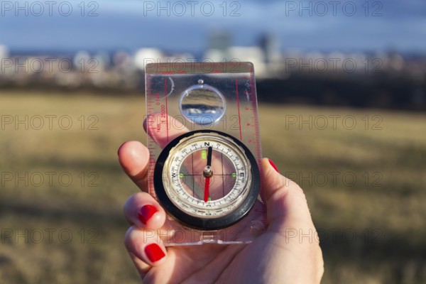 Female hand holding glass compass, nature in background, sunny autumn day, life change and new years resolutions concept Prague Czech republic
