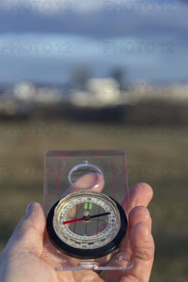 Male hand holding glass compass, nature in background, sunny autumn day, life change and new years resolutions concept Prague Czech republic