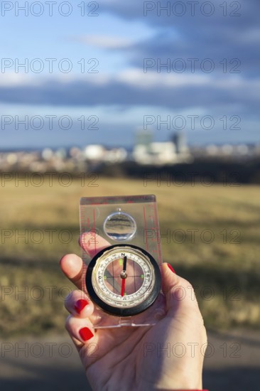 Female hand holding glass compass, nature in background, sunny autumn day, life change and new years resolutions concept Prague Czech republic