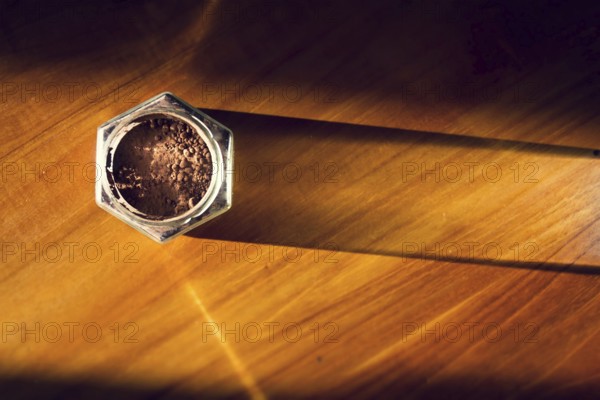 Cocoa powder in glass jar lying on wooden brown table, flat lay view, healthy diet Prague Czech republic