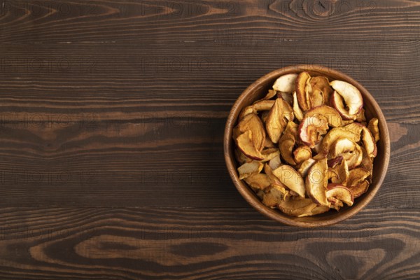 Dried Apples in wooden bowl on brown wooden background. Top view, copy space, flat lay. healthy food, minimalism. sweet