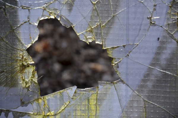 Filtered vintage photograph of hole in a broken security glass