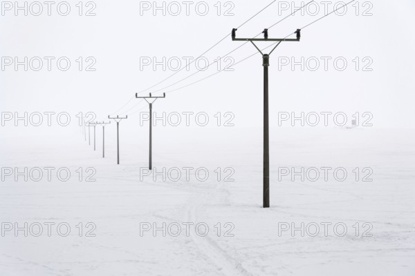 Electricity pylons from distribution power station in foggy winter freeze Prague Czech republic
