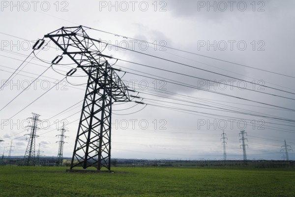 Electricity pylons conducting current from distribution power station with dramatic cloudy sky copy space background Prague Czech republic
