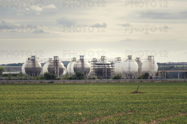 Liquid and fluid gas holder storage, sphere shape container tanks, green field in foreground Prague Czech republic