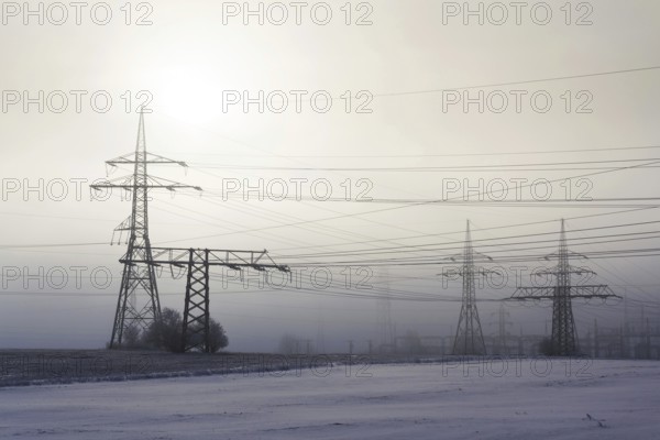 Electricity pylons from distribution power station in foggy winter freeze Prague Czech republic