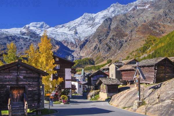 Typical granaries on the outskirts of the village with Alphubel 4206m and Mischabel group 4545m in autumn, Saas-Fee, Saasertal, Valais, Switzerland