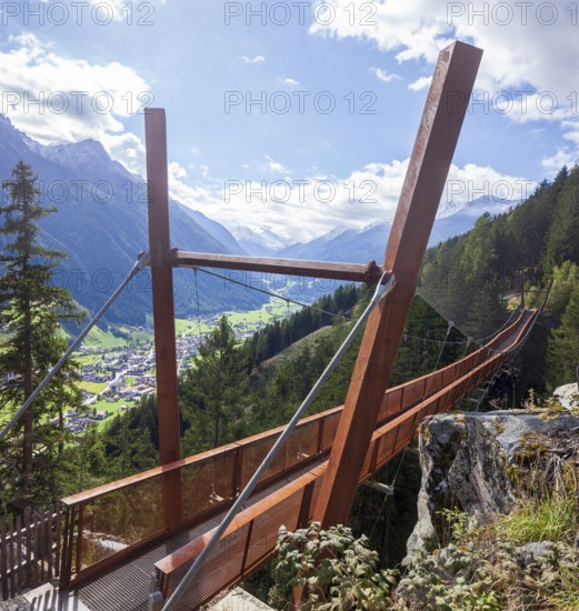 View of Neustift and Stubai Glacier from suspension bridge on the Sunnenseit'n-Weg hiking trail in autumn, Neustift im Stubai Valley, Stubai Valley, Tyrol, Austria