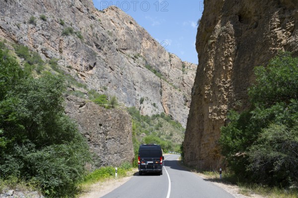 Road through rocky landscape with a black van, camper drives through the Amaghu Gorge from Noravank Monastery, Noravank, Vayots Dzor Province, Vayots Dzor, Armenia, Caucasus