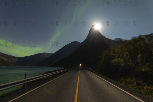 National mountain of Norway, Stetind in the Nordland under auroras and with a full moon shining behind the summit