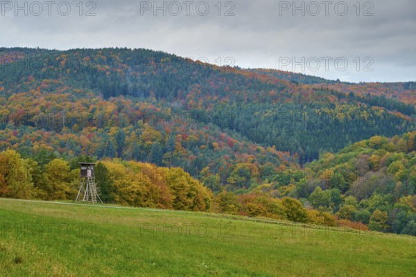Autumn landscape with hunting pulpit, colorful forests and hills under cloudy sky, autumn, Spessart, Bavaria, Germany