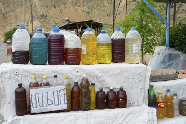 Various juices in plastic bottles at a rural market with mountain scenery, selling wine in Areni village, Vayots Dzor province, Vayots Dzor, Armenia, Caucasus