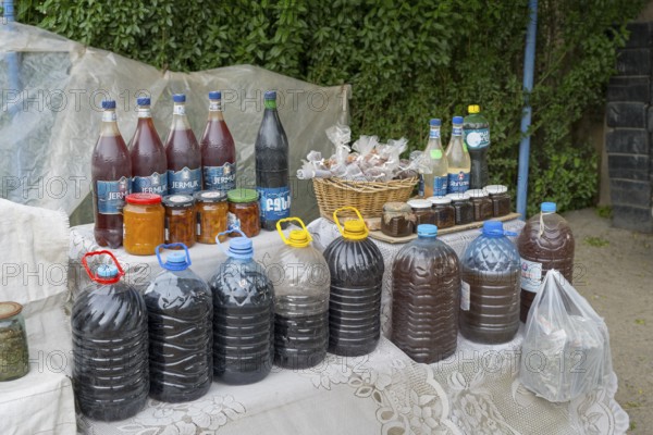 Market stall with various homemade products in bottles and glasses, selling wine and food in Areni village, Vayots Dzor province, Vayots Dzor, Armenia, Caucasus