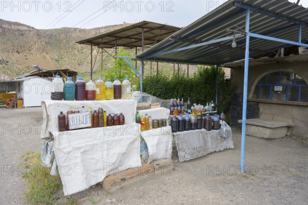 Market stand full of plastic bottles under a covered area selling wine and food in Areni village, Vayots Dzor province, Vayots Dzor, Armenia, Caucasus