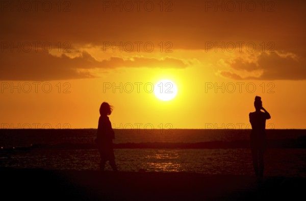 Silhoutte of two girls watching the sunset, Majorca, balearics, spain