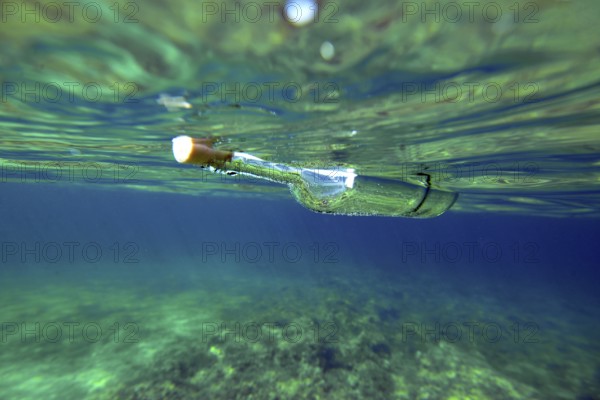 A bottle with a Message is floating under the surface of the mediterranean sea, majorca, balearics, spain