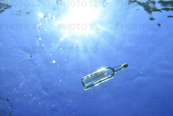 A bottle with a message is floating under the surface of the sea, Majorca, balearics, spain