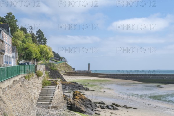Located in Saint-Brieuc Bay, Port du Legue in Saint-Brieuc is bordered by a stone waterfront with historic shipping houses and a lighthouse, while a stone staircase leads to the sandy beach at the mouth of the Gouet, Cotes-d'Armor, Brittany, France