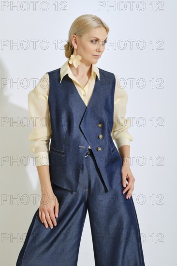 A model showcases a stylish blue vest paired with wide-leg pants and a light shirt. The outfit emphasizes a modern, chic aesthetic perfect for casual outings