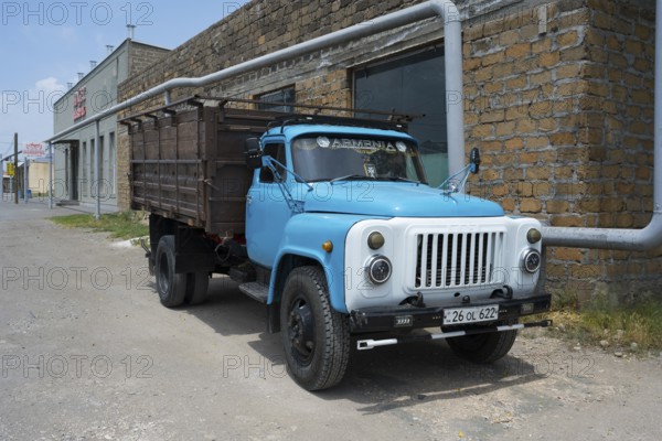 Old blue truck in front of a brick wall in an urban environment, GAZ-53 truck, Ararat, Ararat province, Armenia