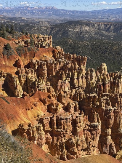 Impressive red rock landscape with sweeping views over layered, smoky rocks, Bryce Canyon National Park is located in southwestern Utah in the United States, view of impressive rocks and red formations in the canyon with mountain scenery in the background, Tropic, Utah, USA