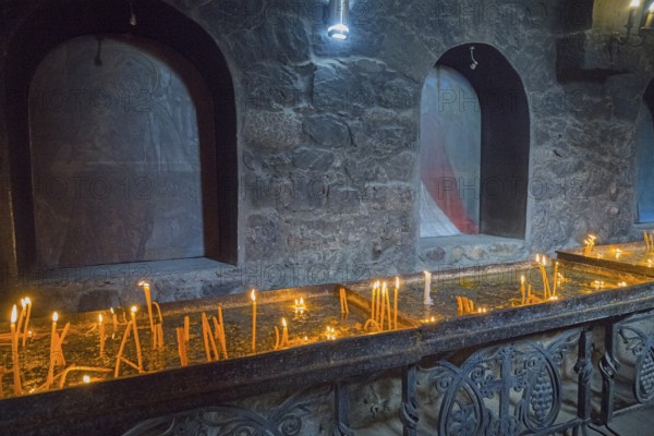 Candlelit room on the altar surrounded by dark stone walls and peaceful atmosphere, Khor Virap Monastery, Deep Dungeon, Ararat Province, Armenia