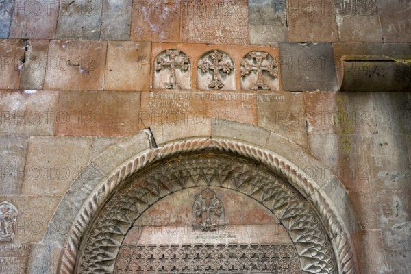 Detailed stone carving with crosses and carvings on an old church wall, Khor Wirap monastery, deep dungeon, Ararat province, Armenia