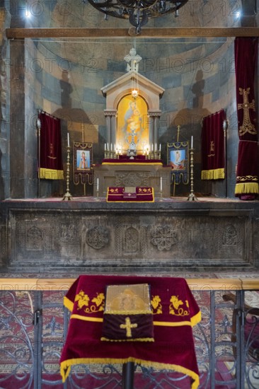 The altar with a variety of religious symbols and candles on decorated textiles, Khor Virap monastery, deep dungeon, Ararat province, Armenia