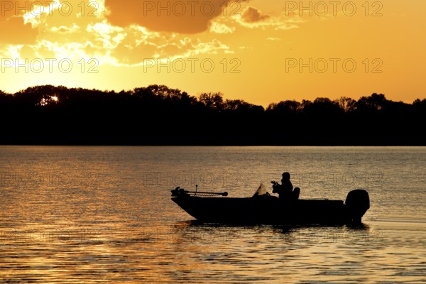 A boat on Lake Gudelack at sunset, Lindow (Mark), Stechlin-Ruppiner Land nature park Park, Brandenburg, Germany