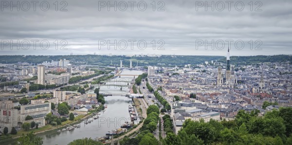 Panoramic view of the Rouen city in France, with the winding Seine river and numerous bridges. Elevated cityscape view from Sainte-Catherine hill with the towering cathedral Notre-Dame de l'Assomption, Rouen, France