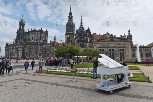 Dresden, Gerrmany- May 6, 2017: Musicians are playing on the sqare in the background Cathedral of the Holy Trinity and Dresden Castle