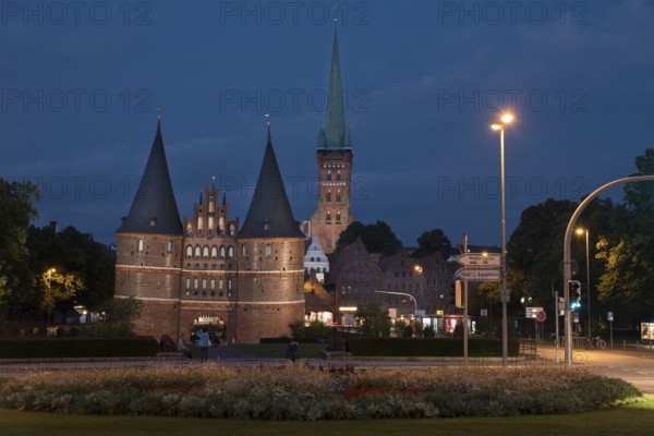 LUBECK, GERMANY - AUGUST 3, 2016: Holstentor Gate and st Jakob church during twilight. Lubeck is the 2nd largest city in Schleswig-Holstein region. Its old town is on a UNESCO World Heritage Site