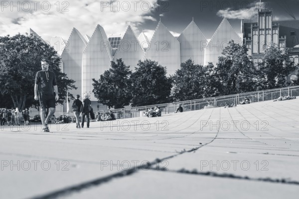 SZCZECIN, POLAND - AUGUST 6, 2017: Passers-by on the pedestrian zone and the Philharmonic building in the background. The building won the main prize in an architectural competition name Miesa van der Rohe 2015