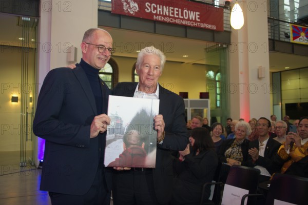 Richard Gere (International Chairman of the International Campaign for Tibet) receives a personal gift from Michael Brand (MdB) (photo of the Dalai Llama at the Brandenburg Gate in 1989), at the presentation of the Snow Lion Human Rights Prize, Umweltforum Berlin, 25.10.2025