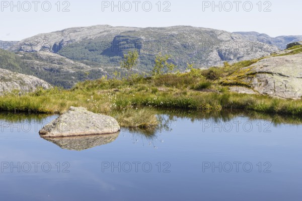 A mountain lake in the alpine tundra landscape of the Scandinavian Mountains near the Preikestolen hiking trail in Rogaland. Seen on a sunny, clear summer day. Vestlandet, Western Norway