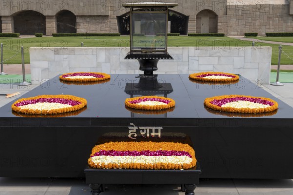 Black marble memorial at Raj Ghat in Delhi, dedicated to Mahatma Gandhi, Mohandas Karamchand Gandhi, the leader of the successful, nonviolent campaign for the independence of India. Location of the monument, with the eternal flame on it, marks the spot on the bank of Yamuna River, where Gandhi was cremated after his assassination. National Capital Territory of Delhi, India