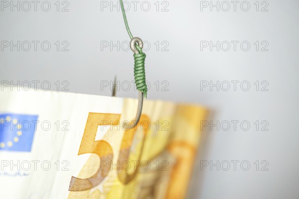 Euro banknote on a fishing hook creating a financial trap, symbolizing risk, temptation, and debt in economy