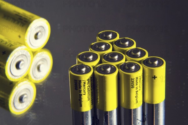 Yellow double A batteries reflecting in mirror, electricity storage concept Prague, Czech republic