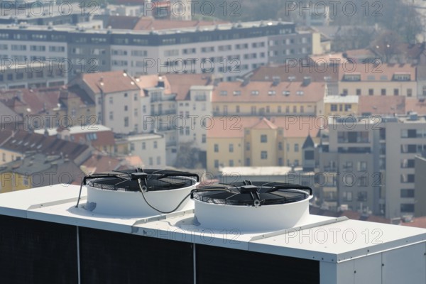 Air conditioning ventilators on roof with houses in background Prague Czech republic